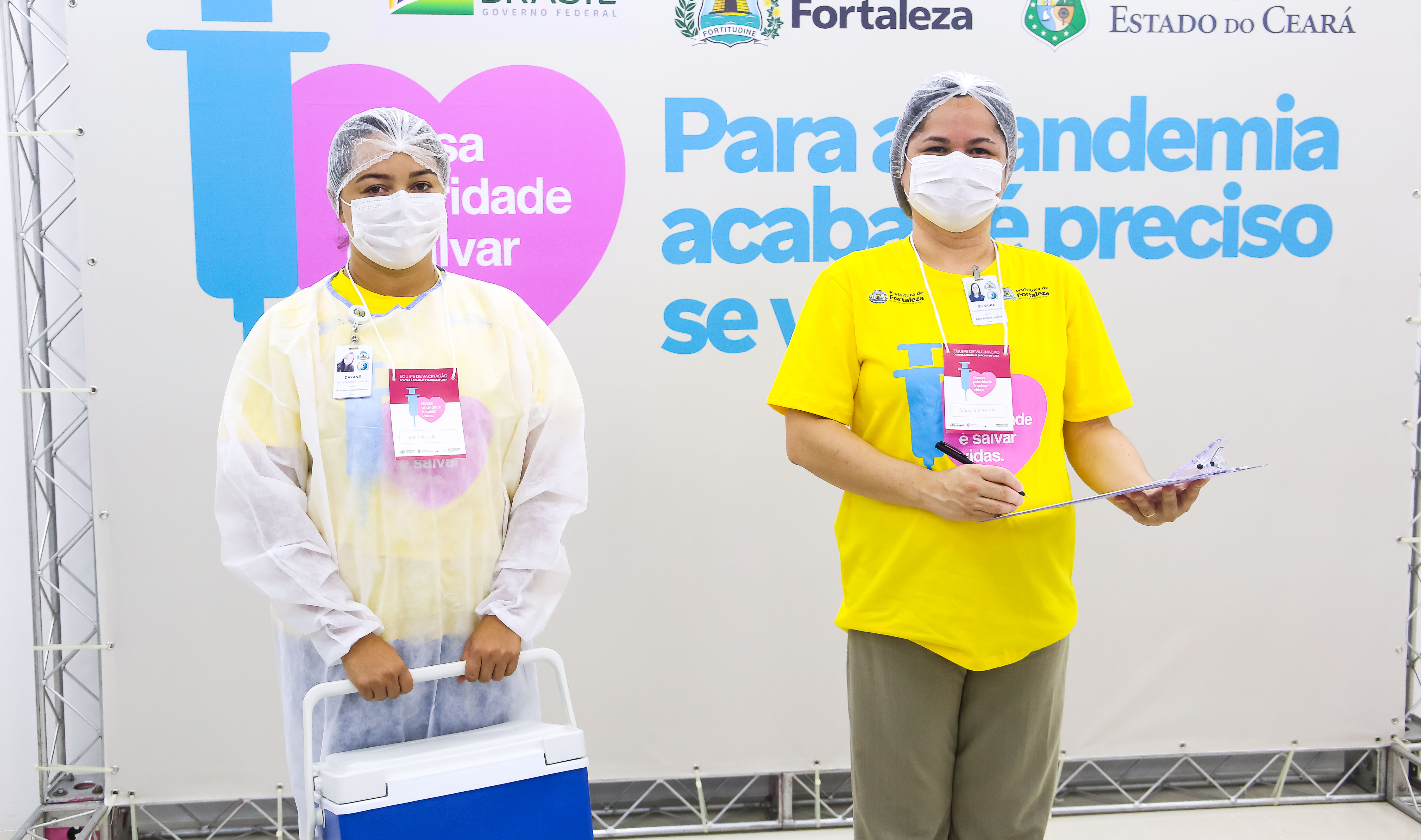 Enfermeiras devidamente uniformizadas e paramentadas com todos os equipamentos de proteção individual (EPIs), além disso, portam crachá de identificação